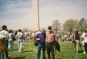 Distant view of Steven Leshner and person holding rainbow flag at event in Washington, D.C. - circa 1990