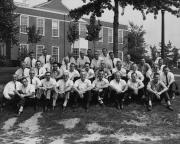 Richard Schlegel with large group of men in front of building - circa 1964
