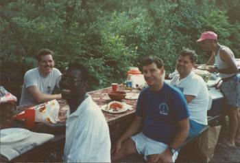 Group of members eating and smiling at the Dignity/Central PA 16th Anniversary Picnic - July 1991