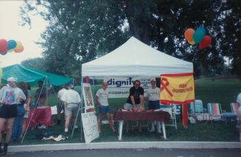Three members standing at the Dignity/Central PA booth at Pride Festival of Central PA - July 31, 1994