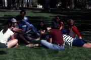 Group sits in the grass, c.1982