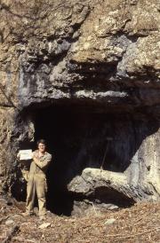 Student stands outside a cave, c.1985