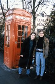 Two students stand next to a phone-booth, c.1990