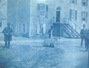 Men standing outside East College, c.1890