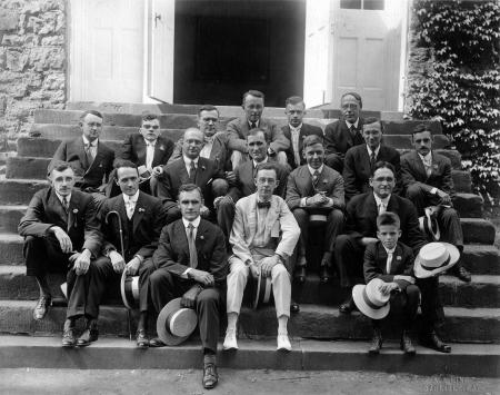 Alumni seated on the steps of West College