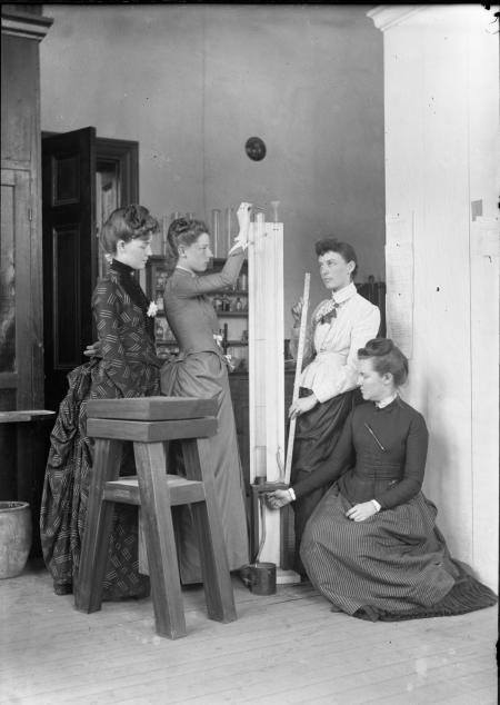 Female students performing science experiment, 1889