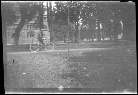 Man riding bicycle past Bosler Hall, c.1890