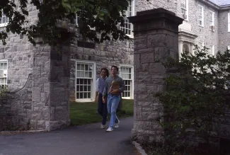 Two students walk through a gateway, c.1985