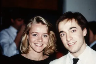 Two friends smile at a party, c.1985