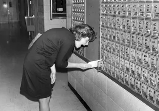 Student checks their mailbox in the HUB, 1985