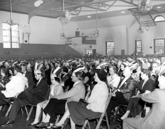 Class of 1930 wearing feathered hats, 1955