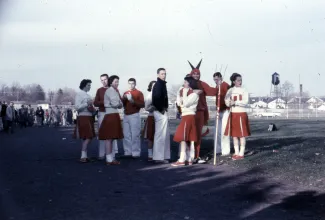 Cheerleaders chatting at a game, 1958